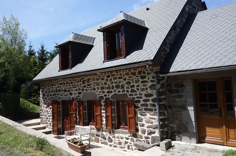 Charming cottage in Le Claux, France, surrounded by nature and rustic architecture.