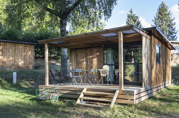 Geniessen Sie die Ruhe auf der Terrasse des Chalet Evasion, einem Ferienhaus in Lanobre in der Auvergne, umgeben von gruener Natur.