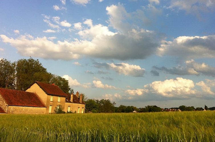 Rustikales Ferienhaus in Annay sur Serein, Burgund, eingebettet in gruene Felder unter einem malerischen Himmel.