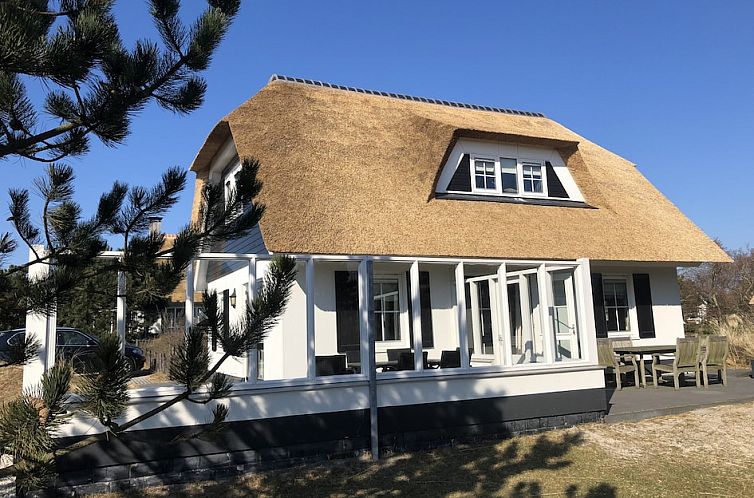 Engelsmanduinvilla 6, een charmante bungalow in Hollum, Ameland, met rieten dak en zonnig terras, omgeven door natuur op de Waddeneilanden.