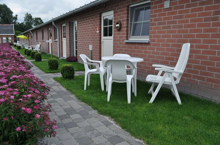 Aussenterrasse von Huisje in Brecht, einem Ferienhaus in Brecht, Antwerpen, mit Sitzgelegenheit und Blumengarten.