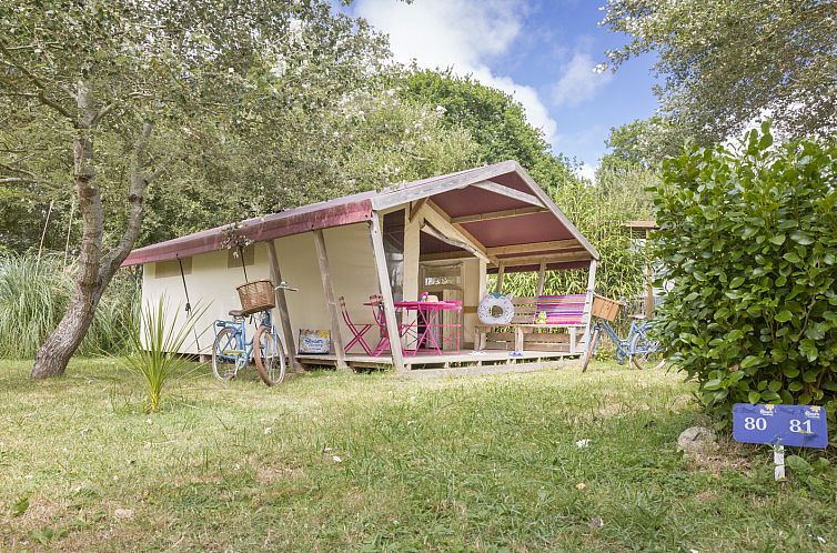Entspannen Sie sich in der Freeflower Standard Glamping-Lodge in Penmarch in der Bretagne, die ueber eine gemuetliche Veranda inmitten von Gruen verfuegt.