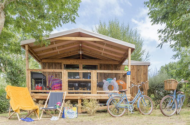 Veranda des "Cosyflower Premium" in Penmarch, Bretagne - ein Ferienhaus inmitten der Natur, ausgestattet mit gemuetlichen Sitzgelegenheiten im Freien.
