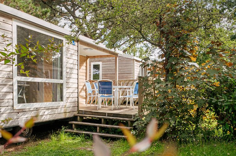 Vakantiehuis Standard Wooden Mobile Home in Bretagne met uitnodigend terras en groene omgeving.