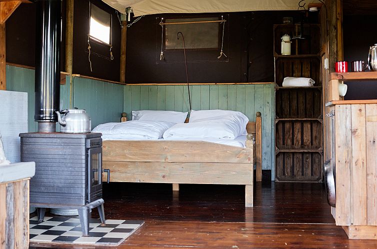 Der Innenraum des FarmersBed Tent in Scaer, Bretagne, Frankreich, bietet ein gemuetliches Schlaferlebnis in einem Safarizelt.