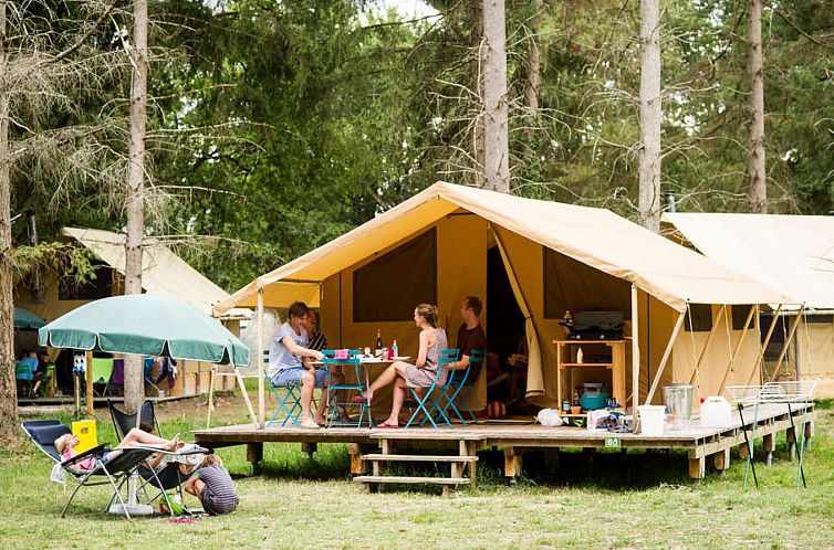 Entspannen Sie sich im Bungalow Tent Classic, einer charmanten Glamping-Lodge in Bracieux, Centre, Frankreich, mit einer grosszuegigen Terrasse in einem bewaldeten Gebiet.