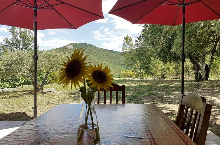 Relax on the terrace of Villa du Castel in Meyrannes, a beautiful vacation home in the Languedoc, overlooking the green hills.