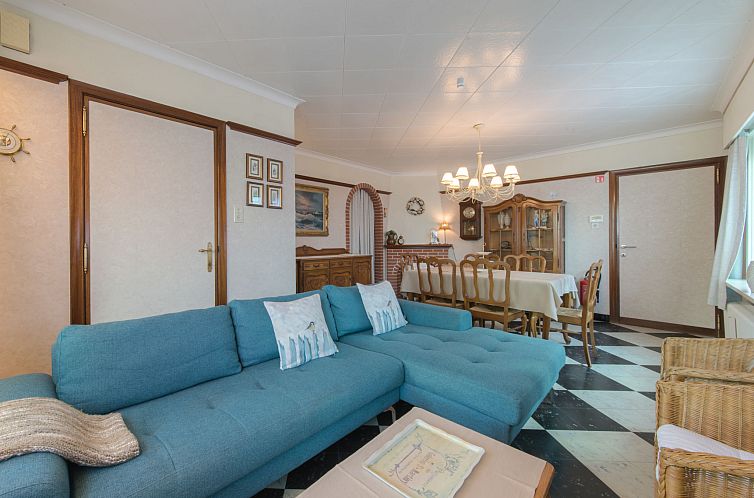 Gemuetlicher Innenbereich des Ferienhauses Villa Martinella in De Haan, Antwerpen, mit komfortabler Sitzecke und elegantem Esszimmer.