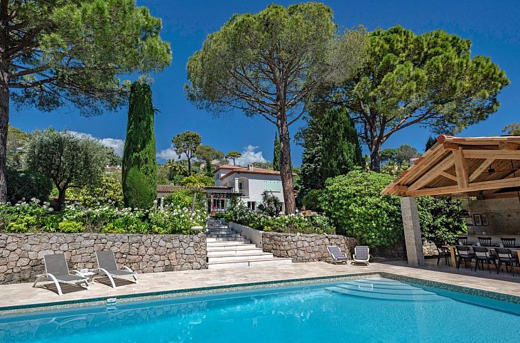 Entspannen Sie sich in Les Palmiers, einem Ferienhaus in Mougins, Cote d'Azur, mit einem schoenen Pool und einer gruenen Umgebung.