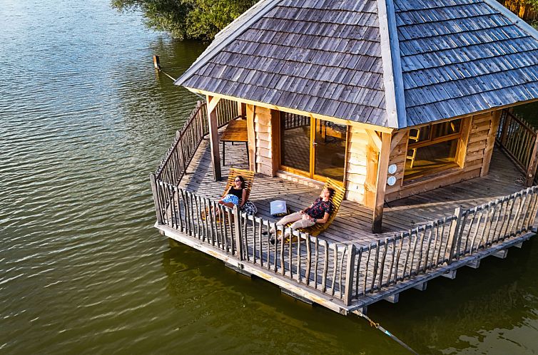 Entspannen Sie sich auf der Terrasse der Huette Ruche, einem idyllischen Ferienhaus am See in Bage-Dommartin, Rhone-Alpes.