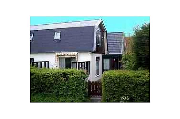 Huisje Schier cottage on Schiermonnikoog with green garden and characteristic architecture on the Wadden Islands.