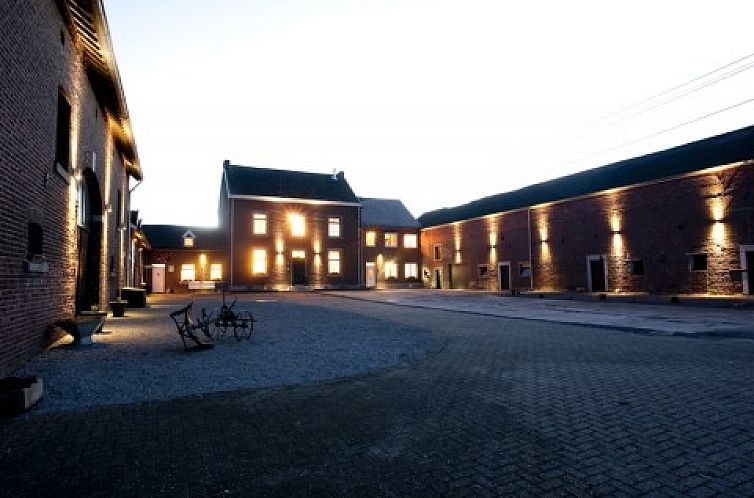 Clermontshof vakantiehuis in Voeren, Limburg verlicht bij schemering met historische charme.