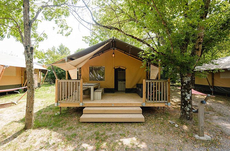 Veranda des Outback-Zelthauses in Saint-Thome, Rhone-Alpes, Frankreich, umgeben von gruener Natur.