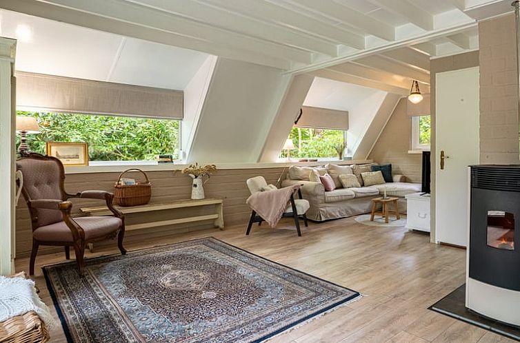 Gemuetliches Wohnzimmer in Cottage in Lanaken, Ferienhaus in Limburg, Belgien, mit bequemer Sitzecke und viel Tageslicht.