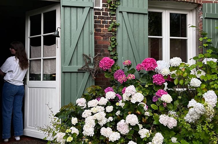 Gezellige ingang van Huisje in Vascoeuil, vakantieverblijf met bloemenpracht in de serene omgeving van Hoog-Normandie, Frankrijk.