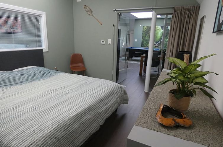 Slaapkamer in Vakantiehuisje in Achel, Limburg, Belgie met comfortabel bed en uitzicht op de tuin.