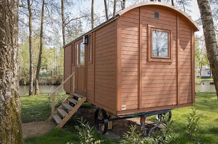 Ferienhaus Camping Papillon Kinrooi - Zirkuswagen fuer 2 Personen im gruenen Limburg, Belgien, mit Blick auf einen ruhigen Teich.