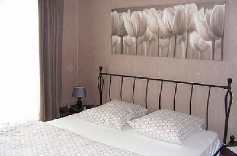 Sfeervolle slaapkamer in Gielkenshoeve vakantiehuis in Bocholt, Limburg, met comfortabel bed en serene decoratie.