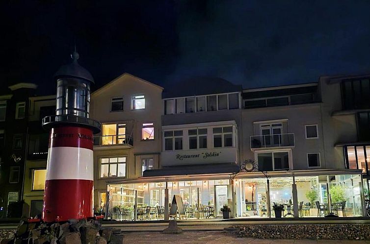 Hotel Restaurant Solskin in Vlissingen, Zeeland, biedt een charmante nachtelijke buitenaanblik met sfeervolle verlichting.