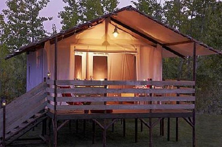Verlicht terras van Cabane Lodge in Loix, Poitou-Charentes, biedt knusse glamping ervaring te midden van groene omgeving.