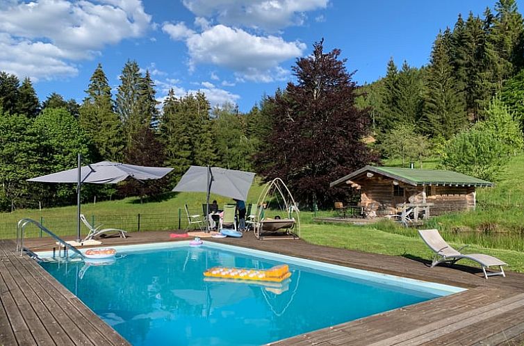 Entspannen Sie sich am Pool des Ferienhauses in Remiremont, umgeben von gruenen Waeldern in Lothringen, Frankreich.