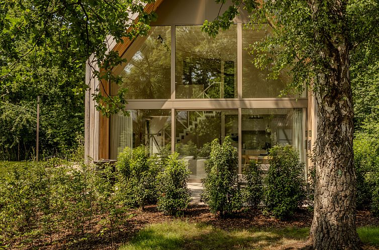 Lodge in Heusden-Zolder, Limburg, Belgium, cottage with glass facade surrounded by lush nature and green surroundings.