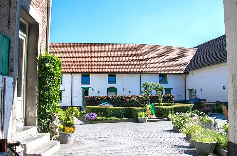 Vakantiehuis in Herderen, Limburg: charmante binnenplaats met groene accenten, ideaal voor een ontspannen verblijf in Belgie.