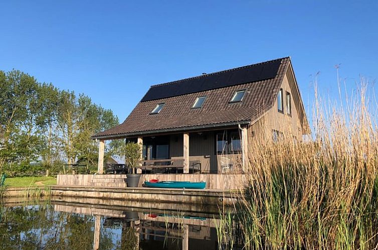 Vakantiehuis in Makkum aan het water, omgeven door riet en natuur, gelegen aan het IJsselmeer in de Friese meren.