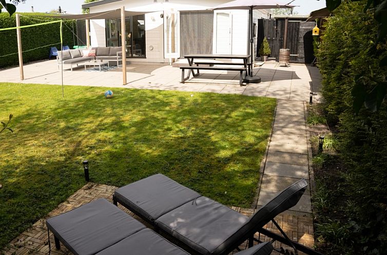 Ontspan op het terras van chalet Zeebries in Makkum, met uitzicht op de groene tuin aan het IJsselmeer, Friese meren.