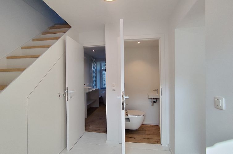 Moderne badkamer in de Vrijstaande woning in Sprimont, Ardennen, Belgie, met lichte inrichting en houten vloeren voor een ontspannen verblijf.