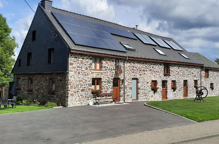 Ferienhaus Les Pierris in Francorchamps, Ardennen, Belgien, mit charmanter Steinfassade und Sonnenkollektoren, umgeben von gruener Natur.