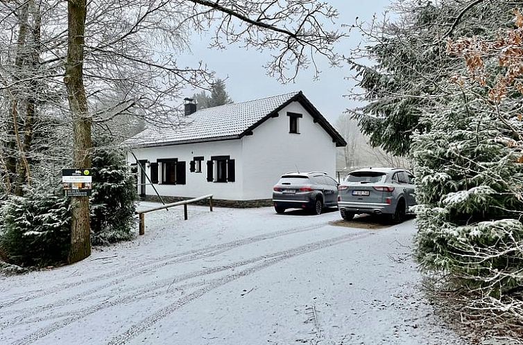 Vakantiehuis in Mont-Malmedy in winterse setting, omgeven door besneeuwde bomen in de Ardennen, Luik, Belgie.