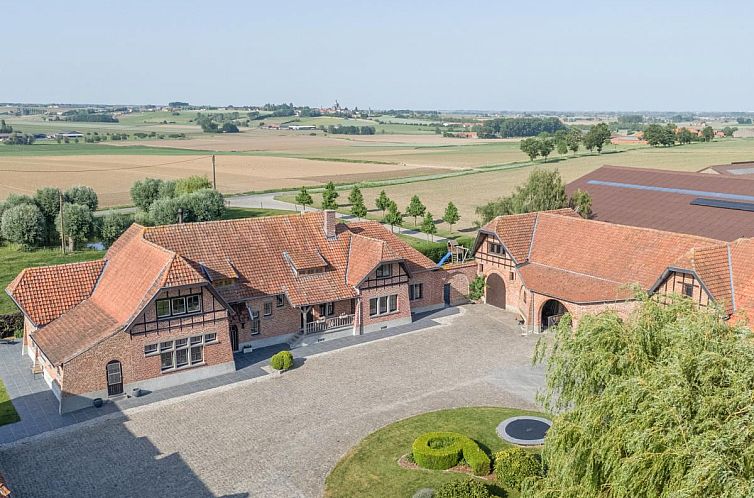 Gemuetliches Esszimmer im Ferienhaus "Rozenberghoeve" in Ploegsteert, Hennegau. Stilvolle Einrichtung mit einem langen Holztisch und stimmungsvoller Beleuchtung.