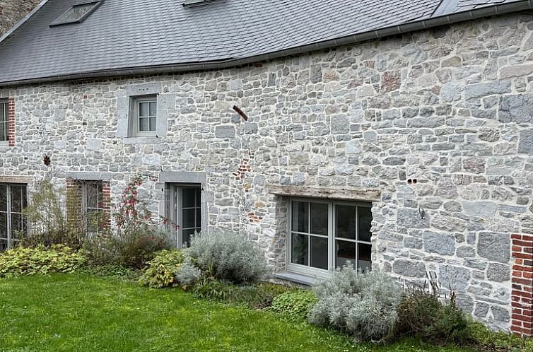 Rustieke stenen gevel van Vakantiehuisje in Sautour, Philippeville, Ardennen, Belgie met groene tuin.