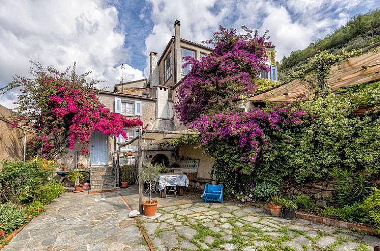 Ontdek Vakantiehuisje in Noli, Italie, met een pittoreske tuin vol bloeiende bougainvillea en een uitnodigend terras.