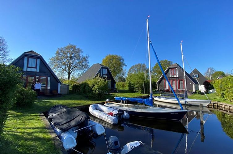 Vakantiehuis in Balk aan het Slotermeer met boten en groene omgeving.