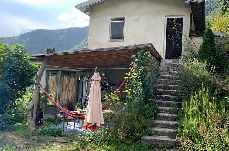 Geniet van de rust op het terras van Huisje in Castel Vittorio, Italie, omgeven door de groene heuvels van Ligurie.