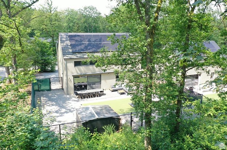 Vakantiehuisje in Barvaux omringd door weelderige natuur in de Ardennen, Belgie, met zonnig terras en moderne architectuur.