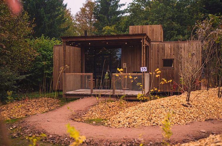 Cozy cottage in Martelange, Ardennes, Belgium with wooden terrace surrounded by nature.