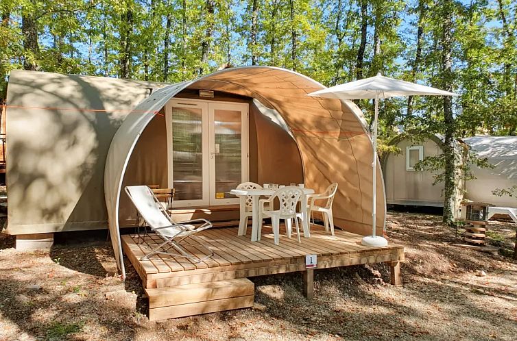 Entspannen Sie sich auf der Veranda der Coco Suite, einem charmanten Safarizelt in Cavriglia, Toskana, inmitten gruener Waelder.