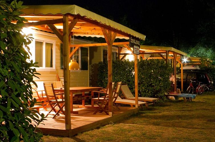 Beleuchteter Terrassenbereich des SunLodge Aspen Combi Ferienhauses in Cavallino-Treporti, Venedig, Italien, fuer einen stimmungsvollen Abend.