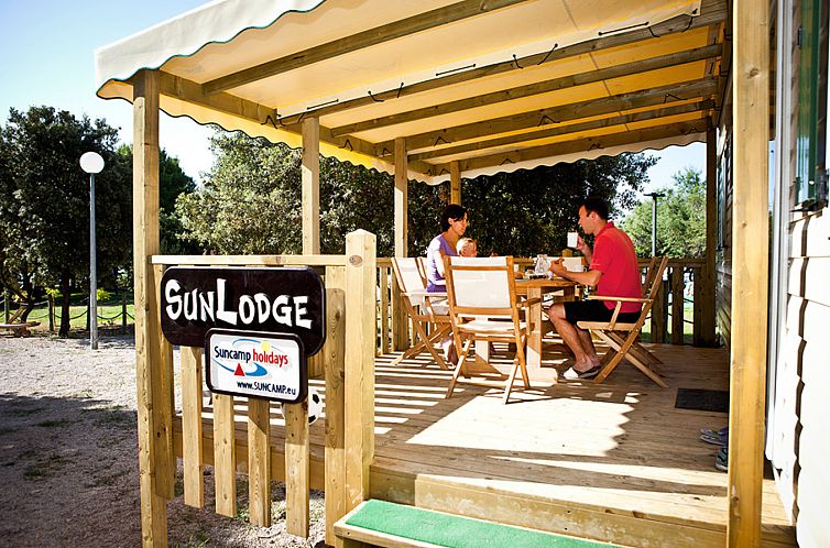 Relax on the terrace of SunLodge Aspen Combi, a vacation home in Cavallino, Veneto, Italy, surrounded by nature.