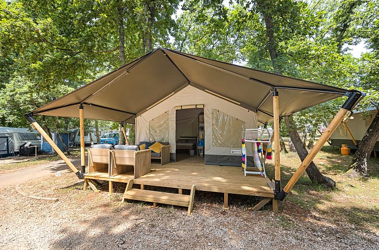 Erleben Sie Glamping im klimatisierten Safari-Zelt Comfort in Novigrad, Istrien. Die Veranda bietet einen atemberaubenden Blick auf die bewaldete Umgebung.