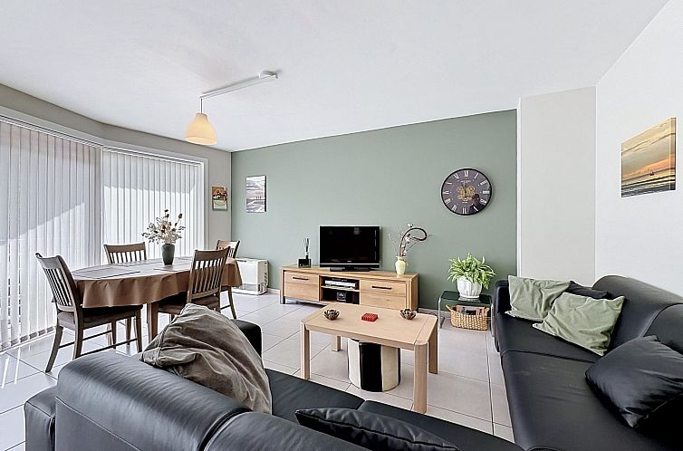 Gemuetliches Wohnzimmer des Appartements Zentral in Blankenberge, belgische Kueste, mit bequemer Sitzecke und Essbereich.