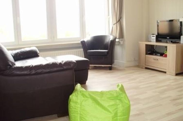 Gezellige woonkamer in het kindvriendelijk vakantieappartement in Bredene, Belgische kust, met comfortabele zithoek.