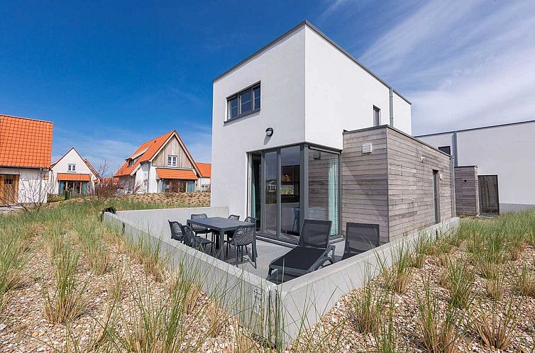 Freistehendes Haus in Bredene, belgische Kueste: modernes Ferienhaus mit Terrasse und Liegestuehlen, umgeben von Duenen und Natur.