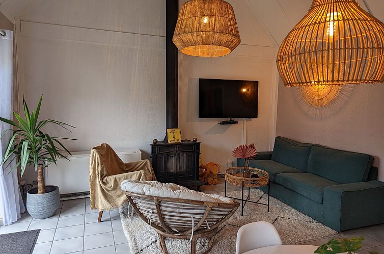 Gemuetliches Wohnzimmer im Ferienhaus Duinendaele II, De Panne, belgische Kueste, mit stimmungsvoller Beleuchtung und bequemer Sitzecke.