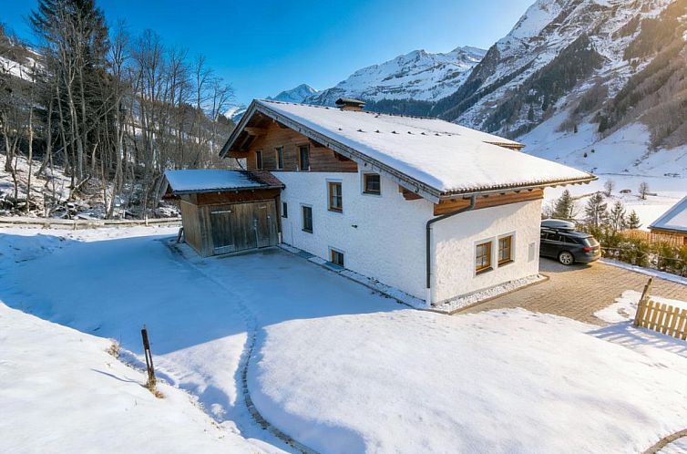 Sfeervol vakantiehuis Barney M in Rauris, Salzburg, omgeven door sneeuw en bergen.