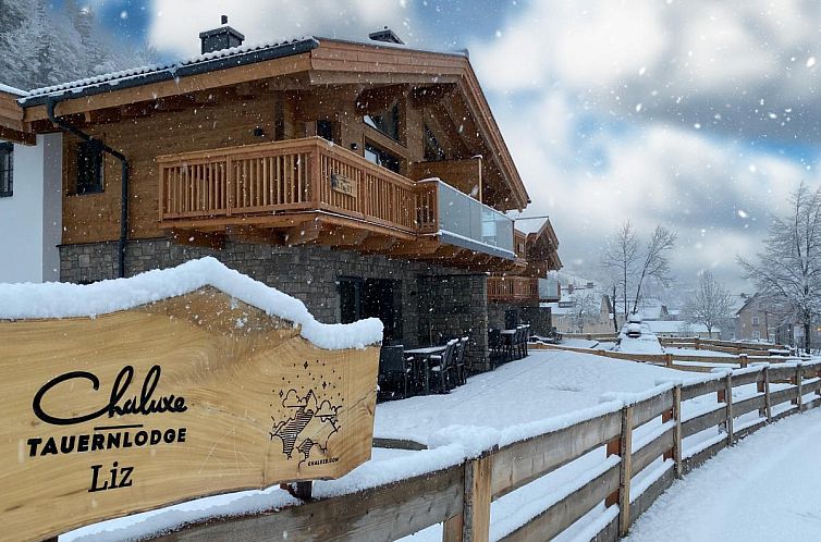 Winter charm at Tauernlodge Mila chalet in Muhlbach am Hochkonig, Salzburg, with snowy views and wooden architecture.
