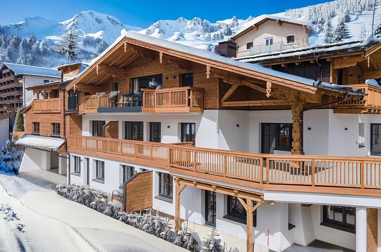 Geniessen Sie den winterlichen Charme des Ferienhauses Sonnblick Top 6 in Muehlbach am Hochkoenig, Salzburg, mit Panoramablick auf die Berge.